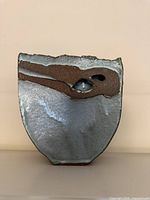 Front view of asymmetrical stoneware vase showing iridescent glaze and pierced relief band