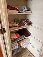 Full closet view showing multiple shelves of folded linens and towels