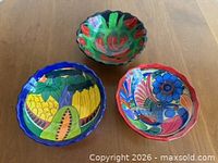 Three hand-painted Talavera footed bowls, showing motifs and scalloped rims