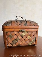 Front view of woven rattan basket showing clasp and metal accent strips