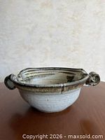 Side view showing bowl form, exterior glaze, both handles