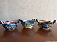 Three Talavera bowls side by side showing exterior patterns and handles