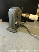 Side view showing tape guide arm, spindle, and overall form