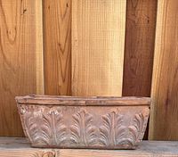 Front view of terracotta planter showing leaf relief and overall shape