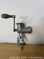 Full view of grinder mounted on edge showing handle and clamp