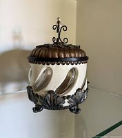 Front view showing entire ornate biscuit jar and decorative metal base