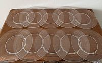 All ten etched glass plates laid out on a table
