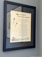 Framed poem print with kites in black frame on wall