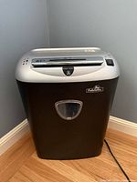 Front view of Fellowes PS-77Cs shredder showing brand badge and waste-bin window