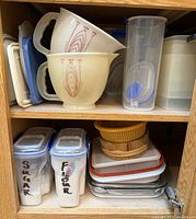 cabinet shelves with bowls, canisters, colander, lids