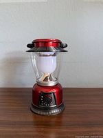 Front view of red LED lantern showing body, globe, handle, control dial