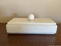 Top view of closed white marble box showing rectangular shape and spherical knob