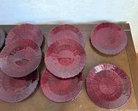 Top view of multiple deep red ridged plates arranged on surface