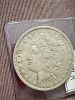 Obverse of 1889-O Morgan silver dollar in plastic sleeve