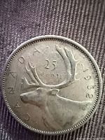 Reverse of 1962 Canadian 25-cent coin showing caribou and date