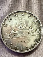 Reverse of 1966 Canadian silver dollar showing Voyager canoe design and date
