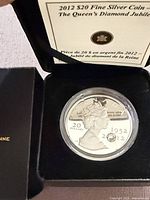 Coin in capsule inside open presentation case showing COA lid