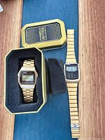 Both gold-tone Casio watches, one in tin box, one laid flat