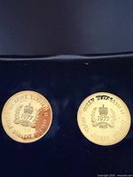Two silver medallions side by side in display; shows both pieces