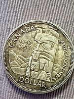 Reverse side of 1958 Canada silver dollar showing totem pole design and inscriptions