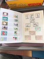 Album open showing two pages of Chinese stamps including fauna and floral designs