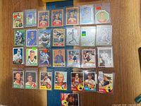 Overall layout of 26 sleeved sports cards on table