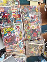 Assorted stacks of bagged comic books on table