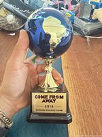 Full view of globe trophy held in hand