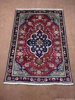 Full view of Tabriz rug showing overall design and fringe