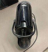 Top view showing DeLonghi logo, two brew buttons, lever handle, power cord