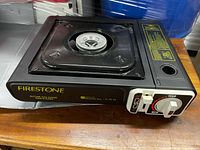 Top and front view of Firestone butane stove showing control dial and branding