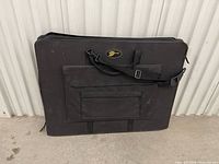 Front view of black nylon portfolio case with handles and shoulder strap