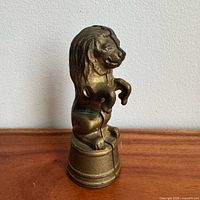 Front view of cast iron lion bank on barrel