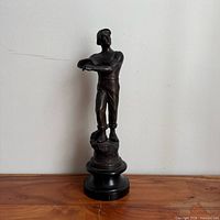 Full view of bronze miner statue on wood base