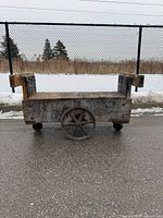 Side view of full wooden trolley showing structure and wheels
