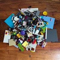pile of assorted LEGO pieces on wood surface