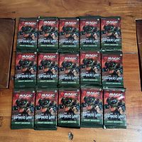 Front view showing 15 sealed The Brothers’ War draft booster packs arranged on table