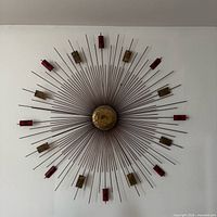 Full view of starburst sculpture on wall showing overall form and attached perimeter elements