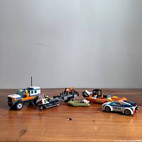 Group shot of all LEGO vehicles, boats, bikes, trailer and minifigures