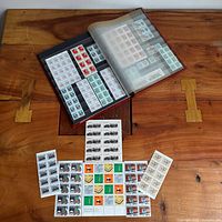 Stockbook open showing multiple full pages of stamps and loose stock sheets