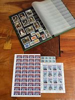 Open stock book showing assorted Canadian stamps and two loose mint panes