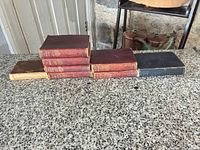 Side view of all seven small hardcover books lined up on countertop
