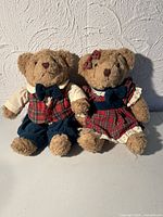Both Beverly teddy bears seated side by side showing outfits