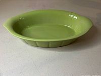 Top-angled view showing lime green oval dish with flared rim