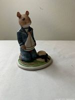 Front view of Rupert figurine holding sailboat