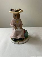 Front view of Amelia figurine seated with notebook