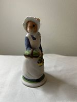 Front view of Daisy mouse figurine showing bonnet, apron, melon and basket