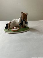 Front view of Harold mouse figurine reclining with plate and cake