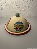 Cheese dome front showing knob, red rim, French label