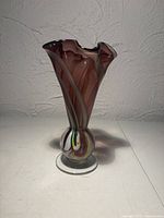 Full side view showing cranberry color, ribbon swirl, footed base